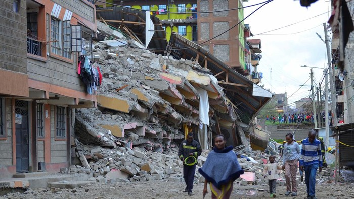 Residents walk past the ruins of a collapsed multi-storey condemned residential building within the Kahawa West residential area in Nairobi, Kenya October 20, 2024. REUTERS/John Muchucha