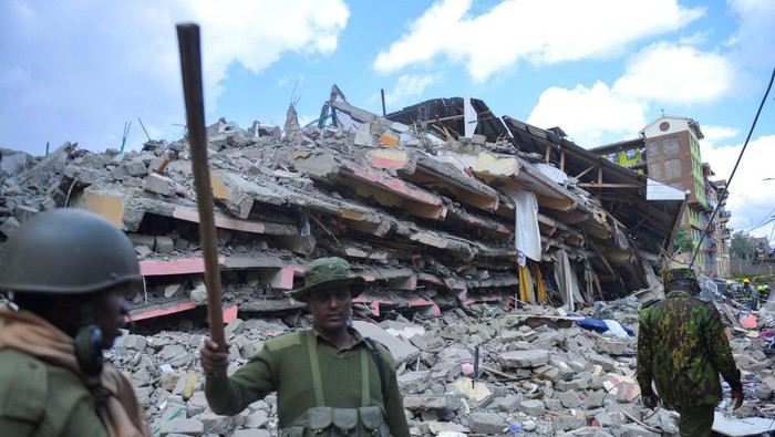 Residents walk past the ruins of a collapsed multi-storey condemned residential building within the Kahawa West residential area in Nairobi, Kenya October 20, 2024. REUTERS/John Muchucha