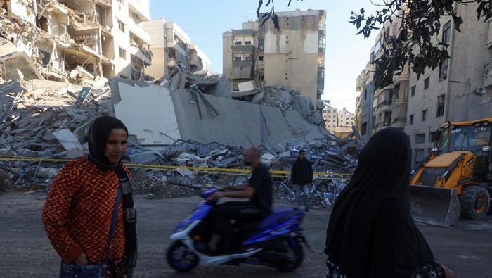 Israel Serang Gedung Lembaga Keuangan Hizbullah A man rides a scooter past a damaged site, in the aftermath of Israeli airstrikes on Sunday that hit several branches of 'Al-Qard al-Hassan', a financial institution linked to Lebanon's Hezbollah, in Chiyah, Lebanon October 21, 2024. REUTERS/Mohamed Azakir