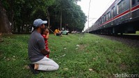 Sebagian dari mereka mengajak anaknya yang masih balita untuk menonton KRL lewat.