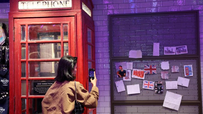 A One Direction fan takes a photo of tributes to Liam Payne, a former One Direction band member, at the Hard Rock Cafe in Piccadilly Circus, in London, Britain, October 18, 2024. REUTERS/Mina Kim