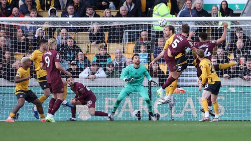 WOLVERHAMPTON, ENGLAND - OCTOBER 20: John Stones of Manchester City beats Jose Sa of Wolverhampton Wanderers with a header to score the winning goal in stoppage time as Bernardo Silva ducks out of the way during the Premier League match between Wolverhampton Wanderers FC and Manchester City FC at Molineux on October 20, 2024 in Wolverhampton, England. (Photo by Alex Livesey - Danehouse/Getty Images)