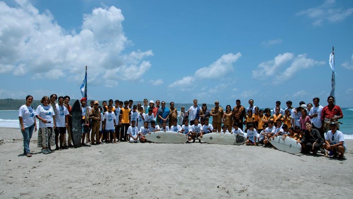 Para peserta beserta undangan berfoto bersama seusai kegiatan pembukaan Kemah Konservasi Selancar di depan Pantai Kerewei, Sumba Barat, NTT.