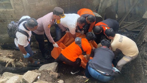 Petugas mengevakuasi lansia yang tewas terpanggang saat membakar sampah di belakang rumahnya di Banjar Pasekan Blodan, Desa Dalam Peken, Tabanan, Bali, Senin (21/10/2024). (Foto: Dok. Polsek Kota Tabanan)