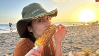 Kalau ini momen Pevita liburan di pantai. Ia menikmati pemandangan matahari terbenam sambil makan jagung bakar. Nyamm! Foto: Instagram pevpearce