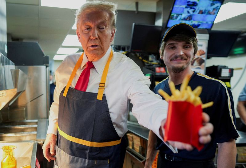 Republican presidential nominee and former U.S. President Donald Trump works behind the counter during a visit to McDonalds in Feasterville-Trevose, Pennsylvania, U.S. October 20, 2024. Doug Mills/Pool via REUTERS