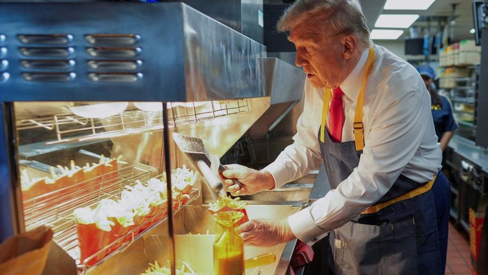 Republican presidential nominee and former U.S. President Donald Trump works behind the counter during a visit to McDonalds in Feasterville-Trevose, Pennsylvania, U.S. October 20, 2024. Doug Mills/Pool via REUTERS