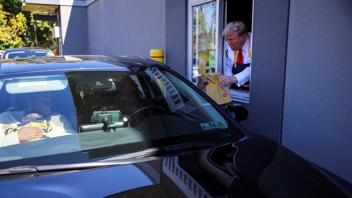 Republican presidential nominee and former U.S. President Donald Trump serves food at a McDonalds restaurant in Feasterville-Trevose, Pennsylvania, U.S. October 20, 2024. REUTERS/Brian Snyder