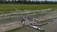 Masyarakat Pribumi Tikuna menerima bantuan dari sebuah LSM akibat kekeringan di sepanjang Sungai Amazon di Santa Sofia, Leticia, Kolombia, Minggu (20/10/2024).