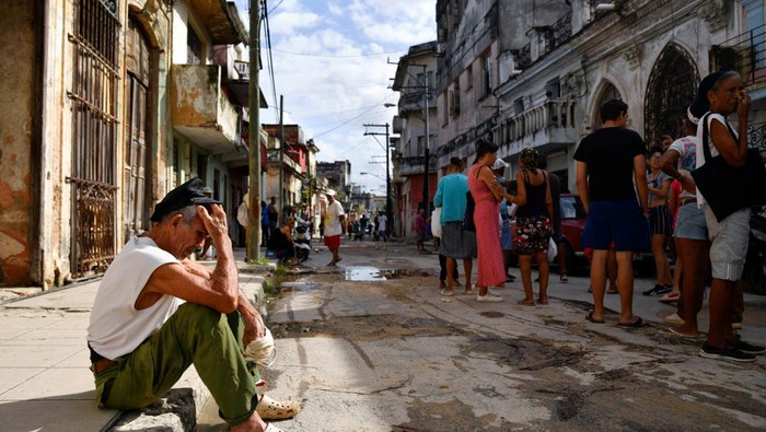 Warga Kuba Depresi Hidup Tanpa Listrik Oney Machado and Diana Machado sit in the house as Cuba suffers a third major setback in restoring power to the island, with millions still in the dark, in Havana, Cuba October 20, 2024. REUTERS/Norlys Perez