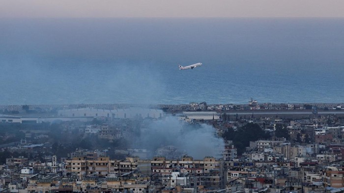 Bandara Internasional Beirut Tetap Beroperasi di Tengah Serangan Israel A Lebanese Middle East Airlines (MEA) plane takes off from Beirut-Rafic Hariri International Airport as smoke billows, amid the ongoing hostilities between Hezbollah and Israeli forces, in Beirut, Lebanon October 22, 2024. REUTERS/Mohamed Abd El Ghany