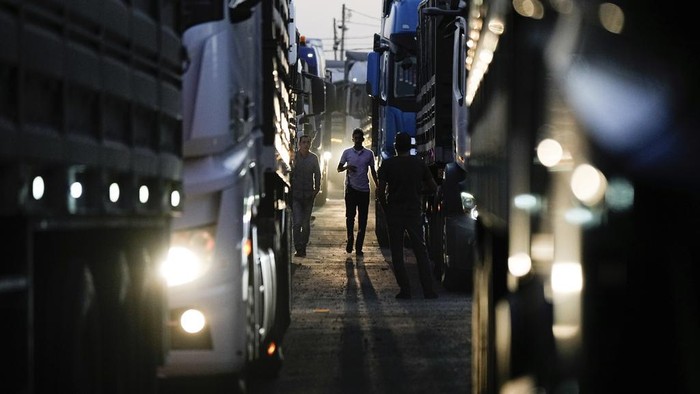 Israeli soldiers stand near trucks carrying humanitarian aid just before they cross into the Gaza Strip at Erez crossing in southern Israel, Monday, Oct. 21, 2024. (AP Photo/Tsafrir Abayov)