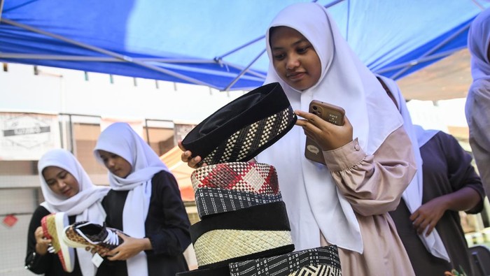 Edukasi kerajinan bambu khas Tangerang di sekolah Sejumlah siswa berswafoto saat mencoba topi bambu di SMAN 15 Kabupaten Tangerang, Banten, Selasa (22/10/2024). Yayasan Topi Bambu memberikan pengenalan dan pelatihan membuat kerajinan bambu seperti topi dan peci sebagai upaya melestarikan warisan budaya khas Kabupaten Tangerang tersebut kepada generasi muda. ANTARA FOTO/Sulthony Hasanuddin/aww.
