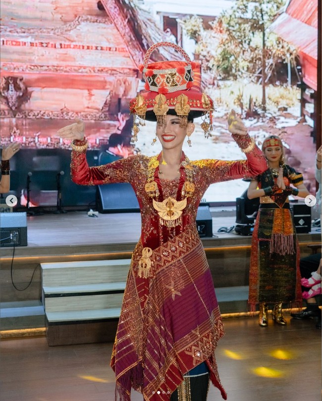 Busana nasional ini bercerita tentang keanggunan dan makna mendalam di balik pakaian tradisional perempuan Karo Batak. Setiap helai kain ulos yang dikenakan menjadi simbol kekuatan, kemurnian, dan kehormatan. Warna merah yang berani melambangkan semangat, hitam menggambarkan kekuatan, dan putih mencerminkan kesucian jiwa. Motif-motif pada kain ini mengisahkan perjuangan dan kebijaksanaan para leluhur yang menjaga tradisi turun-temurun dengan teguh. Foto: Dok. Instagram Puteri Indonesia