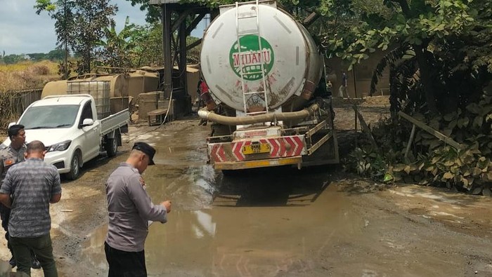 Pembersihan material debu pasca anjloknya katup penampungan semen di Jalan Wates, Argosari, Sedayu, Bantul, Selasa (22/10/2024).