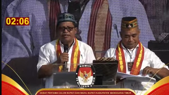 Paslon bupati-wakil bupati Manggarai Timur Agas Andreas-Tarsisius Sjukur (duet Akur) saat memaparkan visi misi dalam debat publik pertama, Selasa (22/10/2024). (Tangkapan layar Youtube Manggarai Timur)