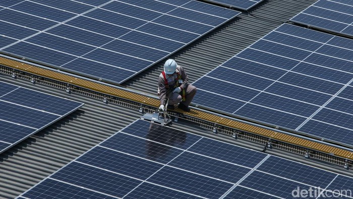 Percepat Transisi Perusahaan Menuju Energi Terbarukan Petugas melakukan pengecekan dan perawatan rutin panel surya di Merck, Jakarta, Selasa (22/10/2024).
