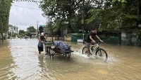 Warga melewati banjir di wilayah Yangon, Myanmar, Senin (21/10/2024).