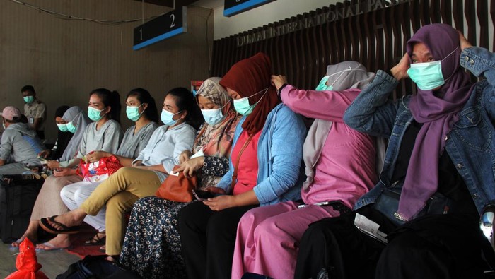 40 Pekerja Migran Indonesia Dideportasi dari Malaysia Sejumlah pekerja migran yang dideportasi dari Malaysia memakai masker di Terminal Penumpang Pelabuhan Dumai, Riau, Selasa (22/10/2024). Sebanyak 40 pekerja migran Indonesia (PMI) yang ditahan di Depot Imigrasi Kemayan Pahang Malaysia dideportasi ke tanah air lewat Pelabuhan Dumai, beberapa diantaranya mengalami gejala gangguan kesehatan seperti demam, terinfeksi saluran pernafasan dan kulit sehingga mendapat penanganan medis dari pihak berwenang di pelabuhan itu. ANTARA FOTO/Aswaddy Hamid/foc.