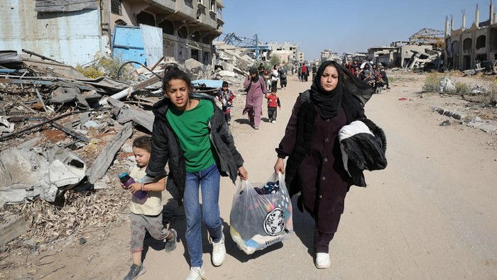Duka Warga Gaza gegara Perintah Evakuasi Israel A displaced Palestinian woman is pushed in a wheelbarrow as she flees after the Israeli military ordered the evacuation of the northern part of Gaza amid a military operation, in Jabalia in the northern Gaza Strip October 22, 2024. REUTERS/Mahmoud Issa TPX IMAGES OF THE DAY