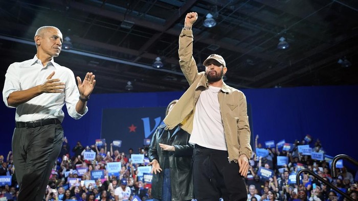 Rapper Eminem, center, greets the crowd on stage with former President Barack Obama, left, at a campaign rally supporting Democratic presidential nominee Vice President Kamala Harris, Tuesday, Oct. 22, 2024, in Detroit. (AP Photo/Paul Sancya)
