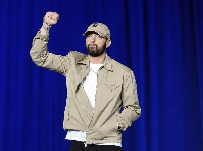 Rapper Eminem, center, greets the crowd on stage with former President Barack Obama, left, at a campaign rally supporting Democratic presidential nominee Vice President Kamala Harris, Tuesday, Oct. 22, 2024, in Detroit. (AP Photo/Paul Sancya)