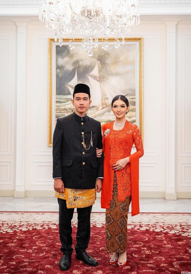 Gibran tampil dengan beskap dan peci. Celana panjang hitamnya dilapisi dengan kain batik berwarna kekuningan. Sementara sang istri, Selvi Ananda mengenakan kebaya berwarna merah. Foto: Instagram/@riomotret
