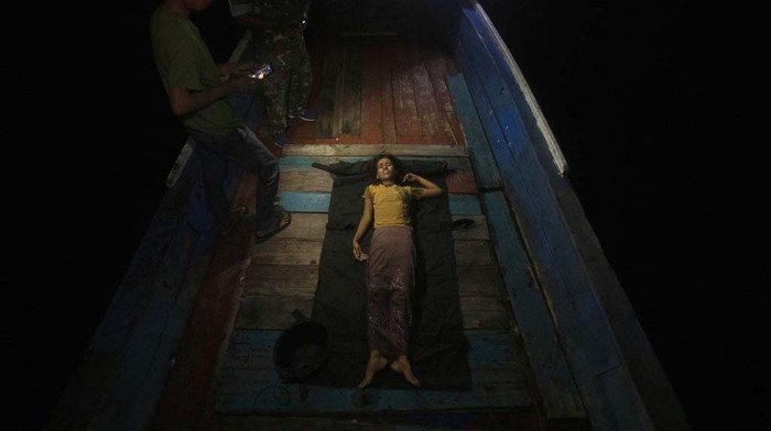 A young Rohingya girl sits on the deck of a refugee boat anchored in the waters near the coast of Labuhan Haji, Aceh province, Indonesia, Tuesday, Oct. 22, 2024. (AP Photo/Binsar Bakkara)