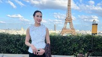 Berlatar Menara Eiffel, Widiyanti memberikan senyuman manis dalam fotonya ini.