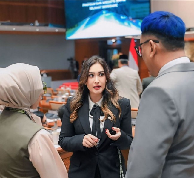 Bergaya androgini saat Rapat Paripurna DPR, wanita 44 tahun ini mengenakan setelan jas hitam dan kemeja putih, serta pita sebagai aksen. Foto: Instagram/@nafaurbach