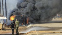 Orang-orang berkumpul di dekat lokasi ledakan truk bahan bakar, di samping jalan raya di pinggiran Kampala, Uganda, Selasa (22/10/2024). (AP Photo)  