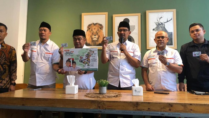 Paslon Pilbup Garut Helmi-Yudi memamerkan kartu Garut Someah