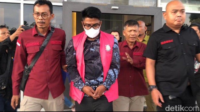 Salah seorang tersangka kasus korupsi tol Padang-Pekanbaru saat hendak dibawa ke mobil tahanan.
(M Afdal Afrianto/detikSumut)