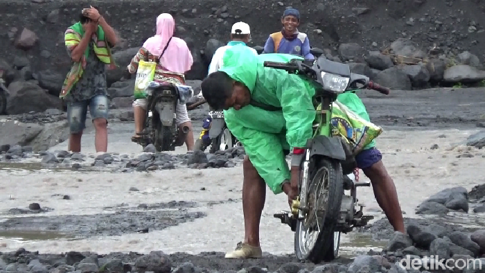 Warga Nekat Sebrangi Aliran Lahar Gunung Semeru untuk Berkativitas saat jembatan limpas tertimbun material