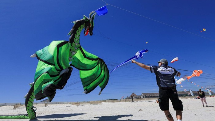 Wow! Ada 'Naga' Terbang di Langit Afrika Selatan Kites fly during a practice run at Dolphin Beach ahead of this weekend's 30thΒ CapeΒ TownΒ InternationalΒ KiteΒ Festival, anΒ awareness campaignΒ for WorldΒ MentalΒ HealthΒ Day whereΒ kiteΒ enthusiasts gather to fly colourfulΒ kites to raise funds forΒ mentalΒ healthΒ support, in CapeΒ Town, South Africa, October 22, 2024. REUTERS/Esa Alexander