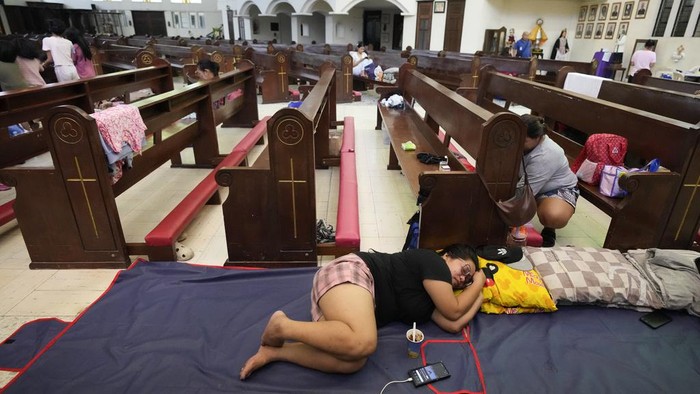 Banjir yang disebabkan Badai Tropis Trami mengakibatkan warga mengungsi di gereja. Begini potretnya.