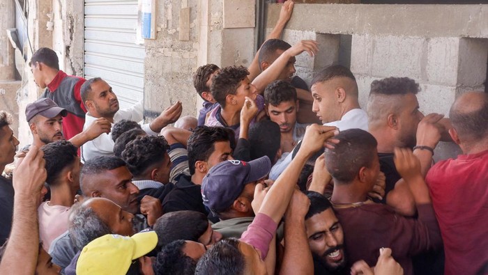 Jangan Lagi Buang Makanan, Lihat Nih Warga Gaza Antre Roti Palestinians gather to buy bread from a bakery, amid the Israel-Hamas conflict, in Khan Younis, southern Gaza Strip October 23, 2024. REUTERS/Mohammed Salem TPX IMAGES OF THE DAY