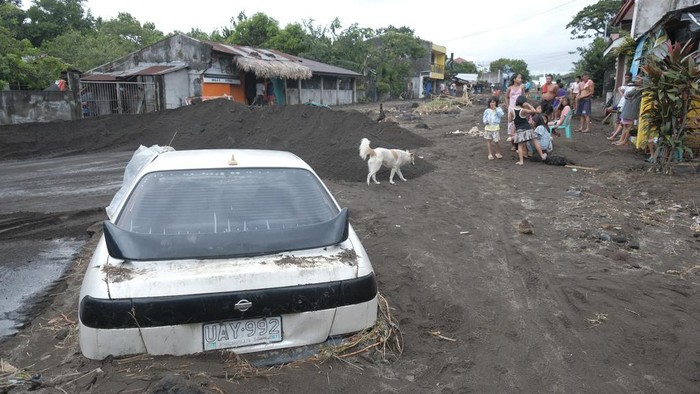 Mobil-mobil di Filipina Terkubur Material Vulkanik Gunung Berapi Men assist a truck as it negotiates a road covered with volcanic mud that flowed down from Mayon volcano after heavy rains caused by Tropical Storm Trami hit Guinobatan town, Albay province, Philippines on Wednesday Oct. 23, 2024. (AP Photo/John Michael Magdasoc)