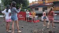 Warga berfoto di depan truk yang terkubur.
