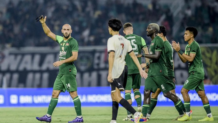 Pemain Persebaya Mohammed Rashid mengangkat pita hitam yang dikenakan setelah mencetak gol ke gawang PSM Makassar