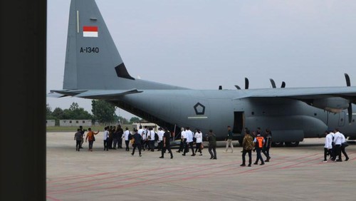 Para menteri Kabinet Merah Putih (berkemeja putih dan topi biru) menaiki Pesawat Super Hercules untuk bertolak ke Magelang, Jawa Tengah, Kamis (24/10/2024). (ANTARA/Rangga Pandu Asmara Jingga)