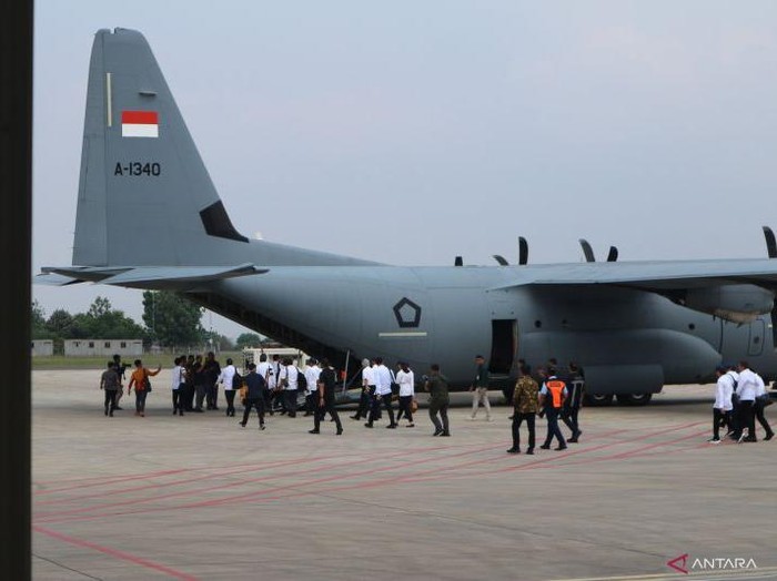 Para menteri Kabinet Merah Putih (berkemeja putih dan topi biru) menaiki Pesawat Super Hercules untuk bertolak ke Magelang, Jawa Tengah, Kamis (24/10/2024). (ANTARA/Rangga Pandu Asmara Jingga)