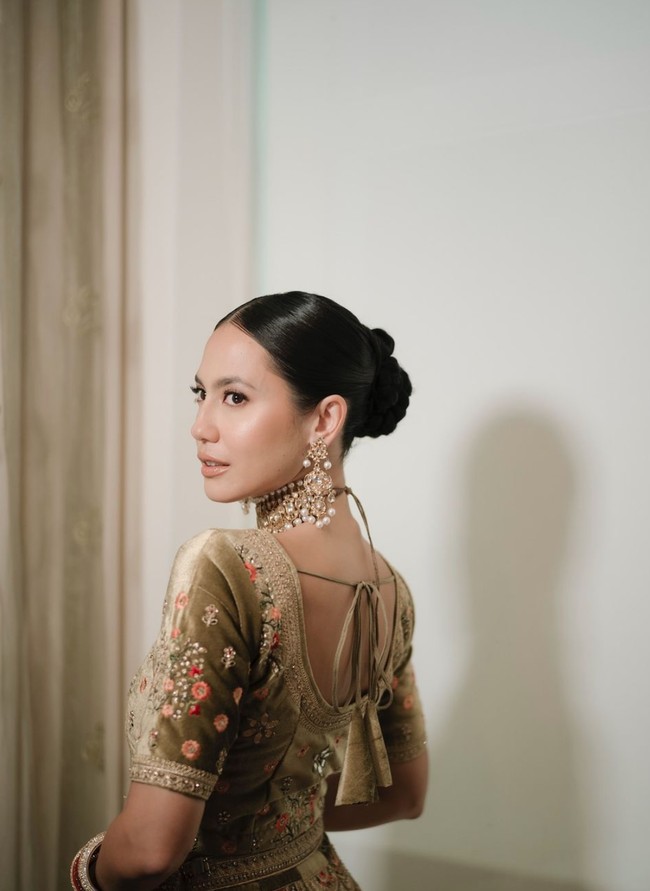 Di acara tersebut Pevita tampil cantik menawan bak wanita India dengan mengenakan lehenga berwarna hijau olive. Lehenga yang dikenakan wanita 32 tahun itu tampak memiliki detail bunga-bunga kecil berwarna merah dan peach. Foto: Instagram/@pevpearce