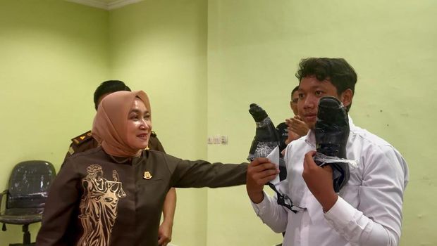 Seorang peserta CPNS di Kejaksaan Tinggi Kalimantan Selatan menghadiri tes dengan sepatu yang rusak penuh rekatan lakban.