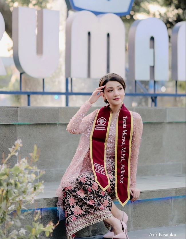 Tsania juga sempat menjalani pemotretan di momen wisudanya tersebut. Kali ini dirinya memilih tampil dengan kebaya berwarna baby pink dipadukan dengan kain batik berwarna hitam-pink. Foto: Instagram/@arti.kisahku