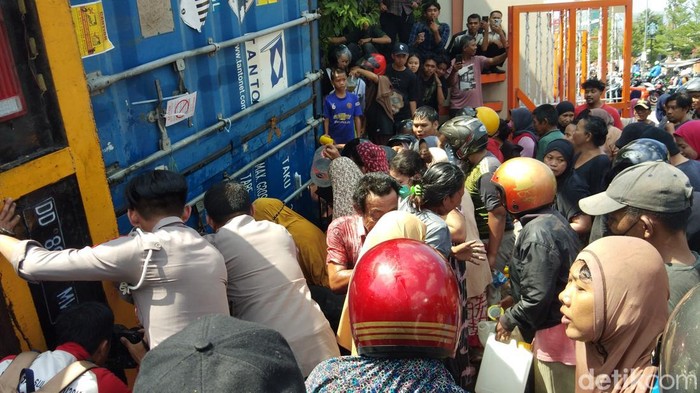 Warga berebutan minyak goreng yang tumpah dari truk kontainer terbalik di depan UNM Makassar. Andi Sitti Nurfaisah/detikSulsel