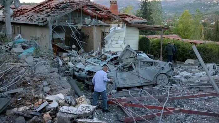People inspect the damage at the site of an Israeli airstrike that targeted an area where a number of journalists were located in the southern Lebanese village of Hasbaya on October 25, 2024. (AFP)
