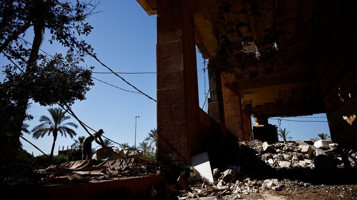 People sit on mopeds near the site of an Israeli strike that destroyed an office used by the pro-Iran Al-Mayadeen broadcaster, amid ongoing hostilities between Hezbollah and Israeli forces, in Beirut suburbs, Lebanon October 24, 2024. REUTERS/Yara Nardi