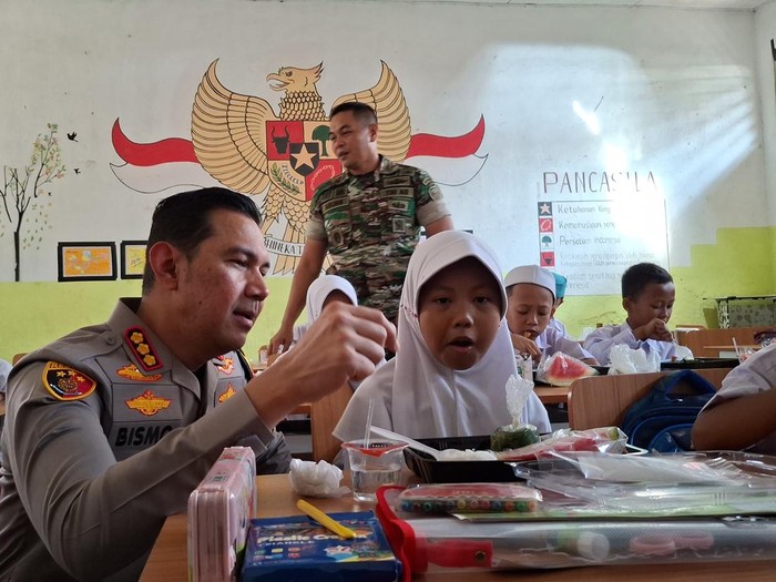 Kapolresta Bogor Kota Kombes Bismo Teguh Prakoso ditemani Dandim 0601 Kota Bogor Letkol Dwi Agung Prihanto bagikan makan bergizi gratis kepada siswa SDN Kebon Kopi, Jumat (25/10/2024).