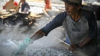 Pekerja melakukan proses penggaraman ikan asin.  
